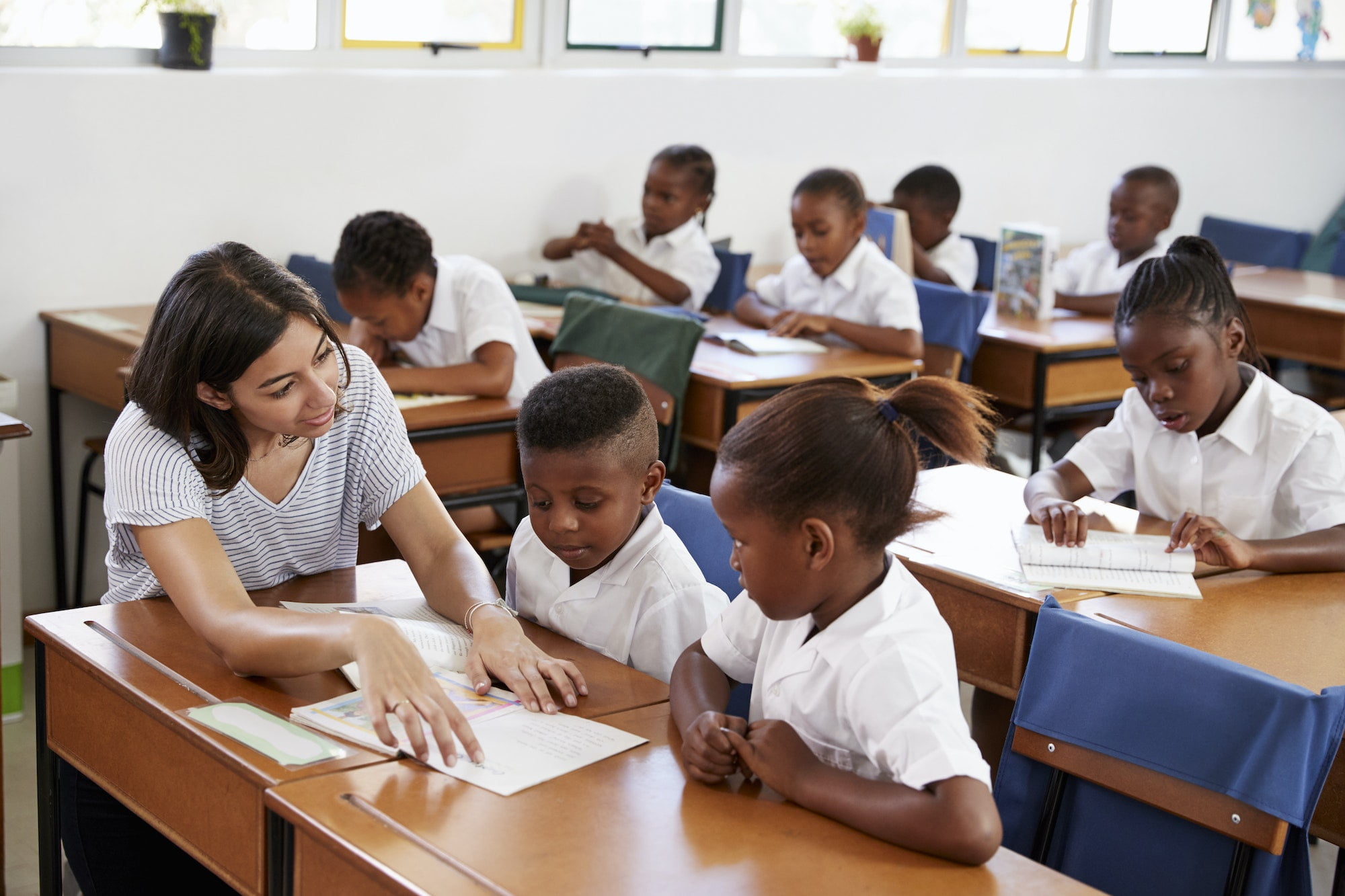 volunteer-teacher-helping-school-kids-at-their-desks.jpg